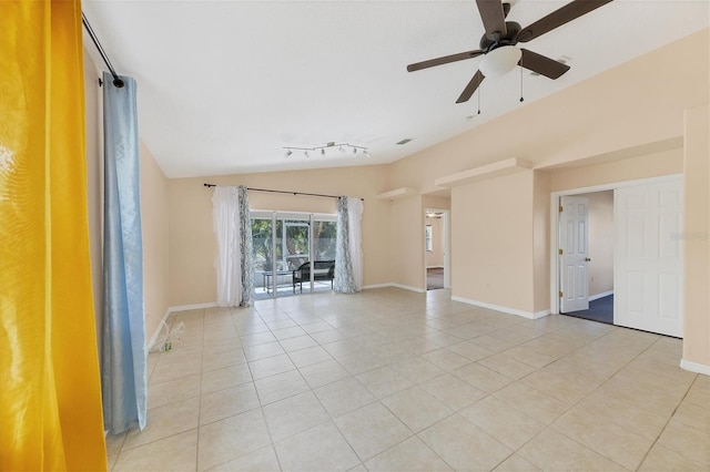 tiled empty room featuring lofted ceiling, ceiling fan, and rail lighting