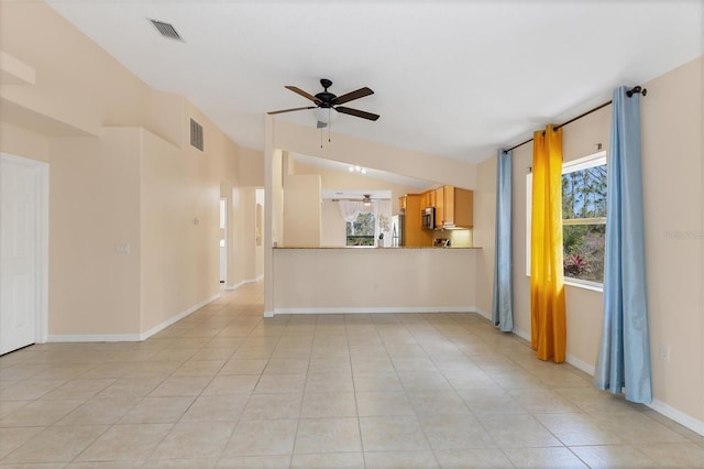 interior space with lofted ceiling, plenty of natural light, ceiling fan, and light tile floors