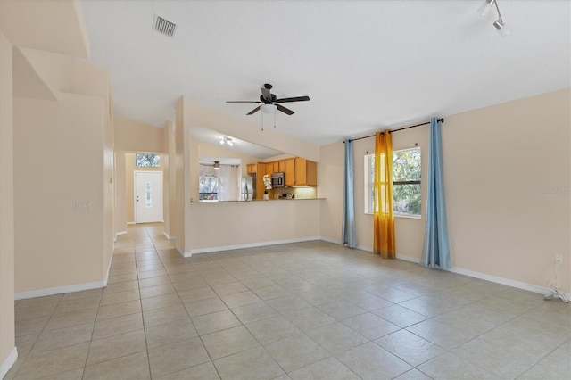 unfurnished living room featuring ceiling fan, light tile flooring, and vaulted ceiling