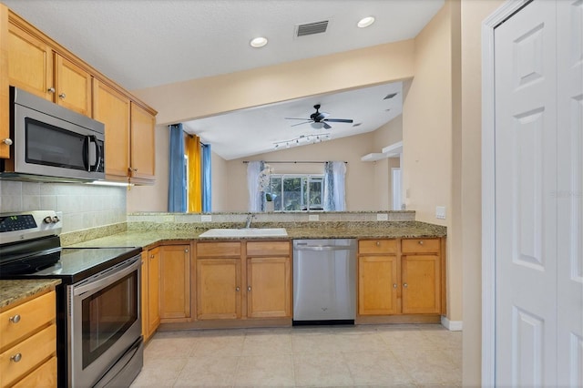 kitchen with kitchen peninsula, lofted ceiling, ceiling fan, appliances with stainless steel finishes, and light tile floors