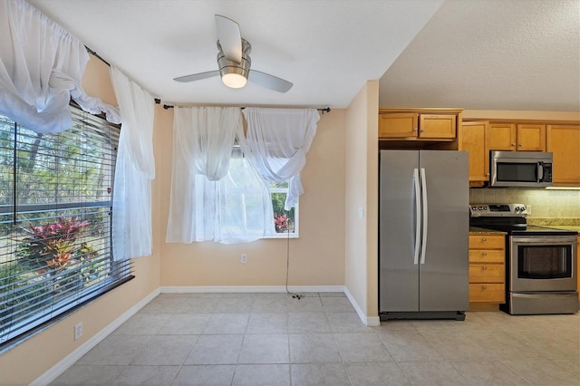 kitchen with light tile flooring, plenty of natural light, and stainless steel appliances