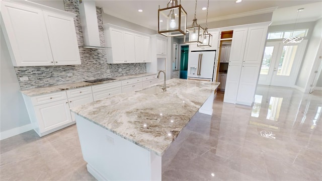 kitchen with white cabinetry, an island with sink, white fridge with ice dispenser, and decorative light fixtures