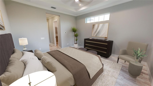 bedroom with ceiling fan, light wood-type flooring, crown molding, and a tray ceiling