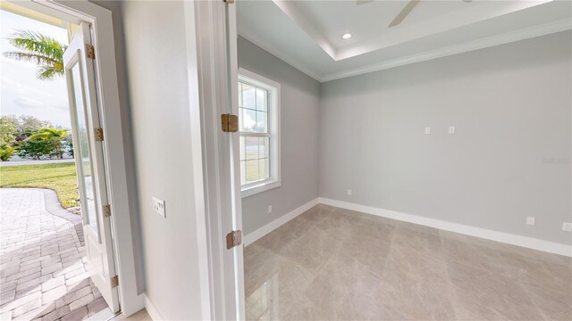 interior space with ceiling fan, ornamental molding, and a raised ceiling