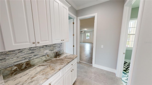 interior space featuring a wealth of natural light, ornamental molding, tasteful backsplash, and vanity