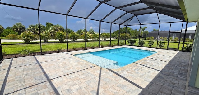 view of pool with glass enclosure and a patio area