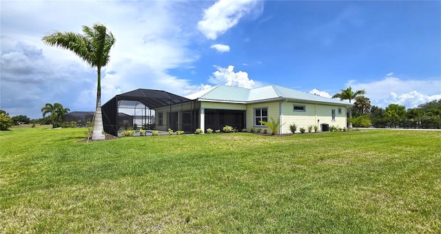 back of property with a lanai and a lawn