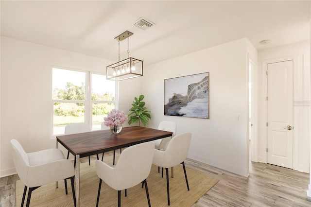 dining area featuring light hardwood / wood-style floors and an inviting chandelier