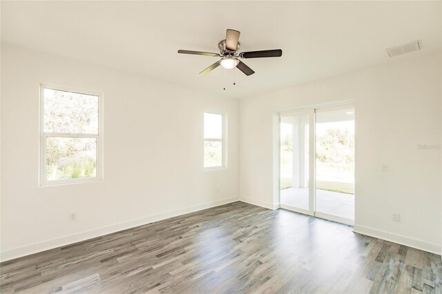 unfurnished room with dark hardwood / wood-style floors, ceiling fan, and a wealth of natural light