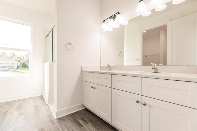 bathroom with vanity with extensive cabinet space, hardwood / wood-style floors, and double sink