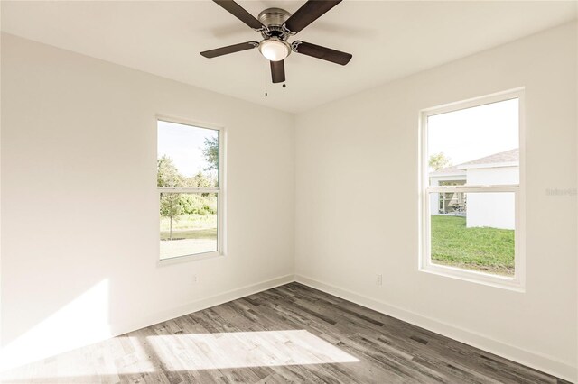 spare room with dark hardwood / wood-style flooring, ceiling fan, and a wealth of natural light