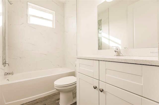 full bathroom with hardwood / wood-style flooring, vanity, toilet, and tiled shower / bath combo