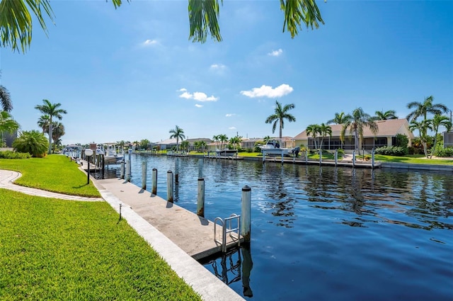 view of dock featuring a lawn and a water view