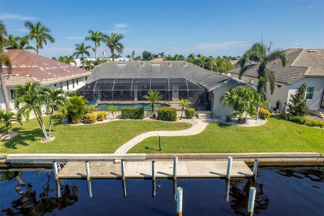 back of property featuring glass enclosure, a yard, a water view, and an outdoor pool