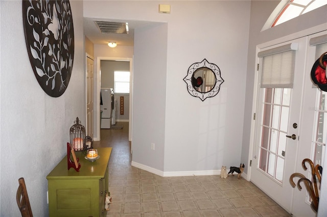 interior space with washer / dryer, french doors, and light tile flooring