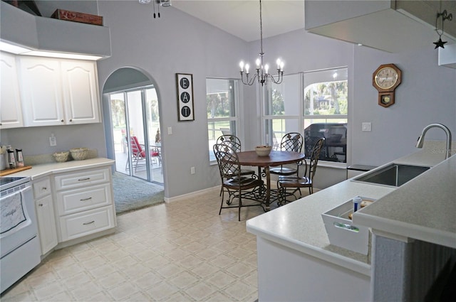 tiled dining area with a notable chandelier, high vaulted ceiling, and sink