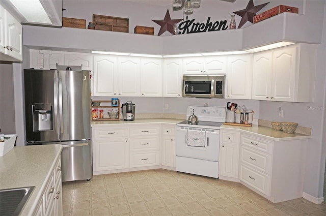 kitchen with white cabinets, appliances with stainless steel finishes, and light tile floors