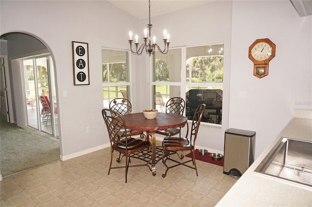 tiled dining room featuring plenty of natural light, vaulted ceiling, and an inviting chandelier