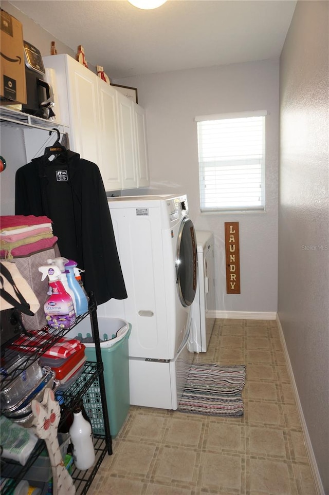 laundry room featuring cabinets, light tile flooring, and washing machine and dryer