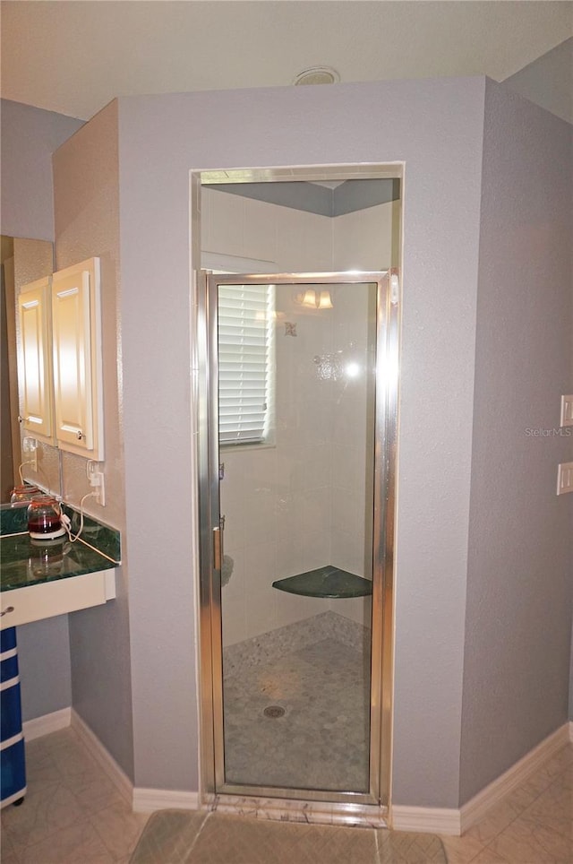 bathroom with tile floors and an enclosed shower