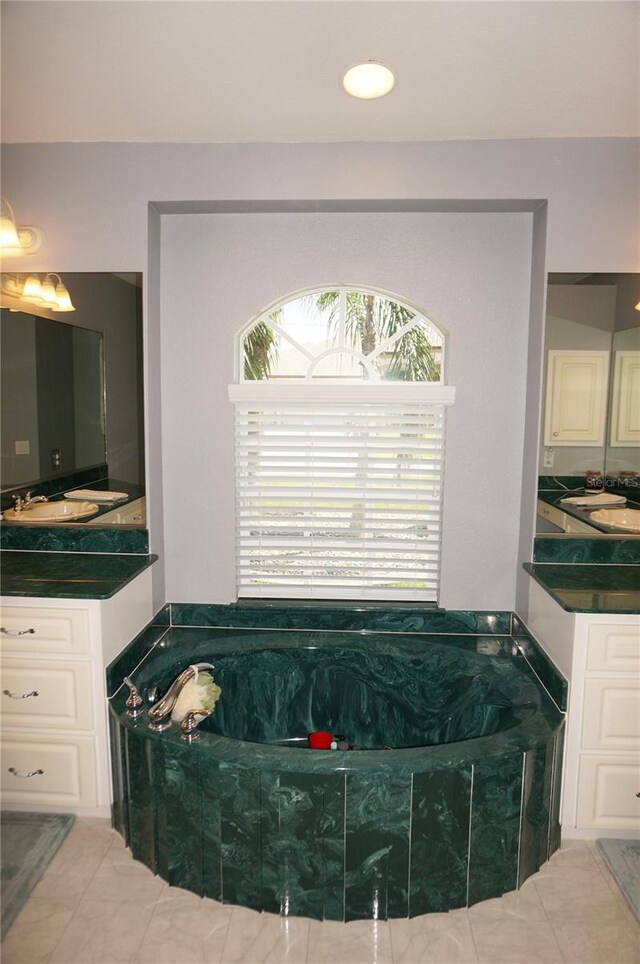 bathroom featuring tile floors, vanity, and a washtub