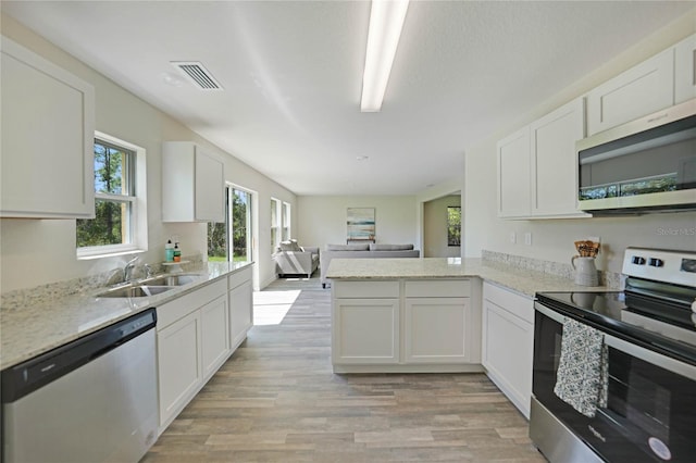 kitchen with white cabinets, light hardwood / wood-style floors, sink, and stainless steel appliances