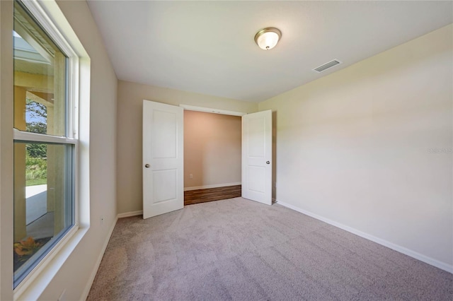 unfurnished bedroom with light colored carpet