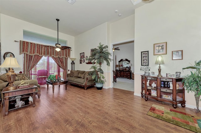 living room featuring wood-type flooring and ceiling fan