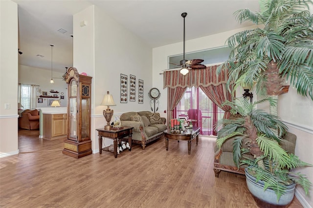 sitting room with ceiling fan, a wealth of natural light, and light wood-type flooring