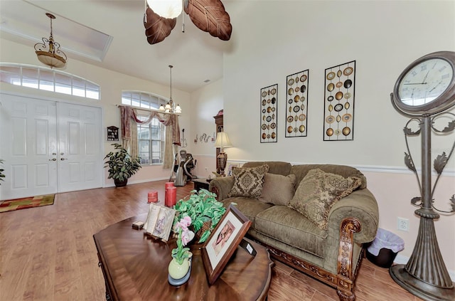 living room featuring light wood-type flooring and ceiling fan with notable chandelier