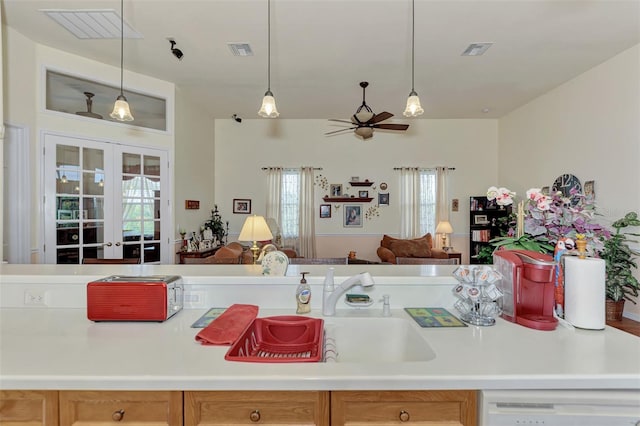 kitchen with french doors, ceiling fan, sink, hanging light fixtures, and dishwashing machine