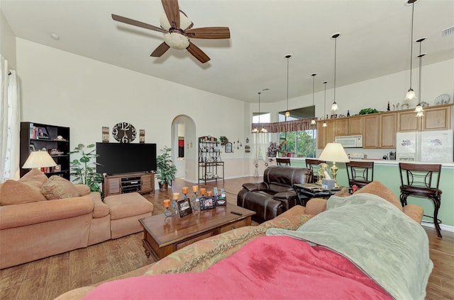 living room with light hardwood / wood-style floors and ceiling fan with notable chandelier