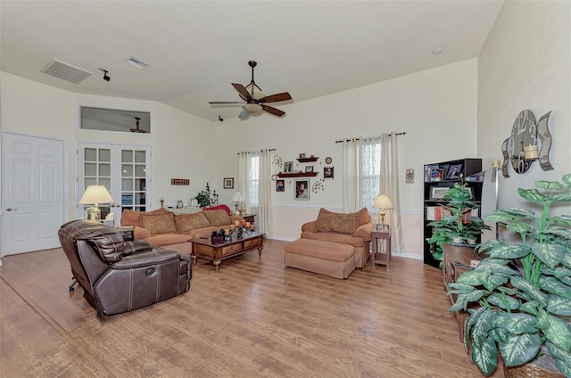 living room featuring ceiling fan, light wood-type flooring, and french doors