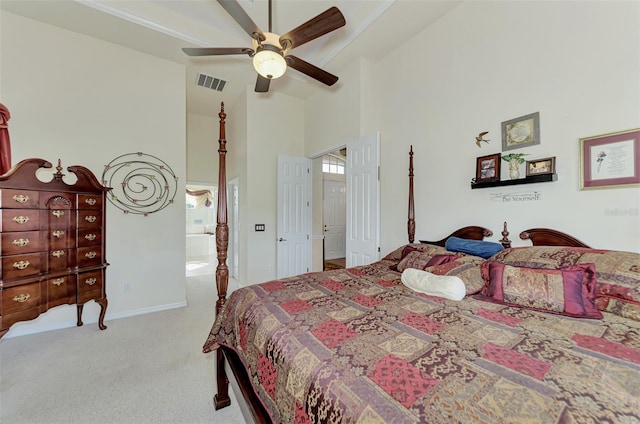 carpeted bedroom featuring ceiling fan and a high ceiling