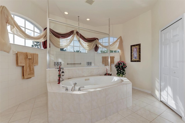 bathroom featuring a relaxing tiled bath and tile flooring