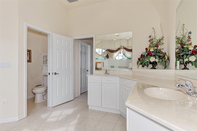 bathroom with tile flooring, toilet, and vanity