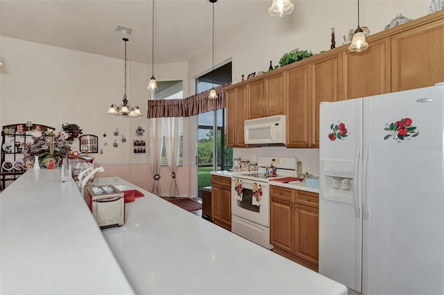 kitchen featuring a chandelier, decorative light fixtures, and white appliances