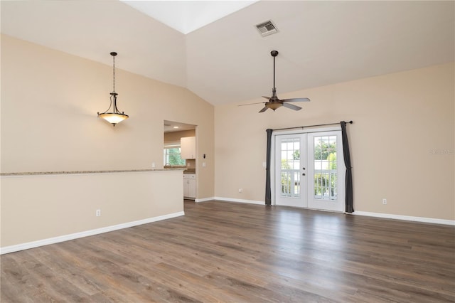 empty room featuring dark hardwood / wood-style floors, vaulted ceiling, ceiling fan, and french doors