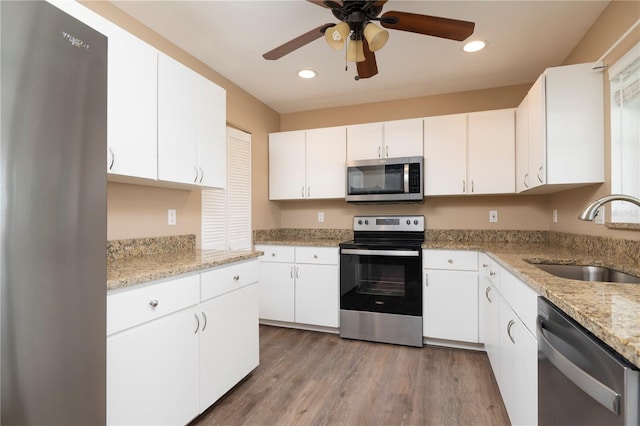 kitchen featuring white cabinetry, ceiling fan, appliances with stainless steel finishes, light hardwood / wood-style floors, and sink