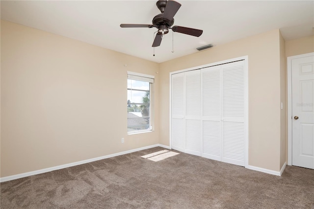 unfurnished bedroom featuring a closet, dark colored carpet, and ceiling fan