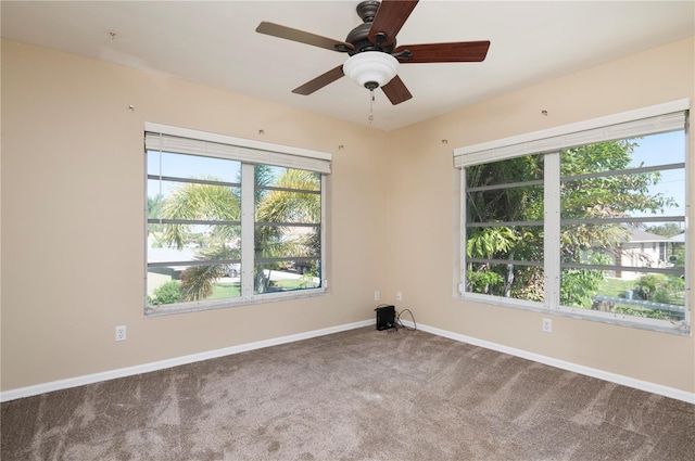 carpeted empty room featuring ceiling fan and a wealth of natural light