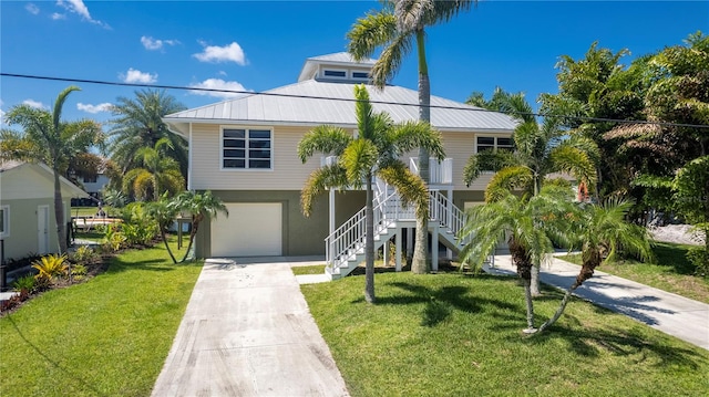 coastal inspired home with a front lawn and a garage