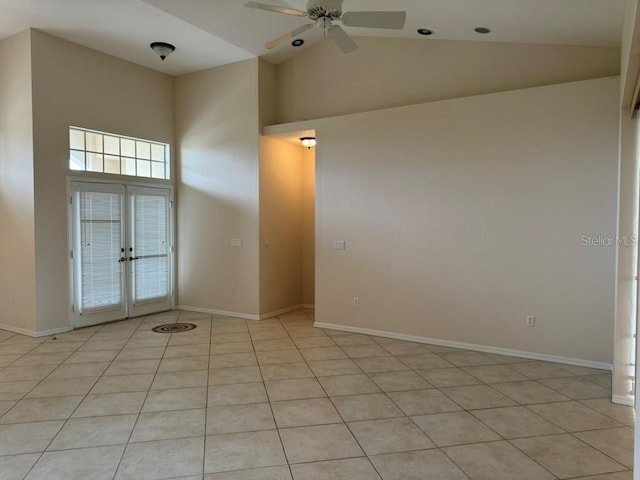 tiled spare room featuring ceiling fan, high vaulted ceiling, and french doors