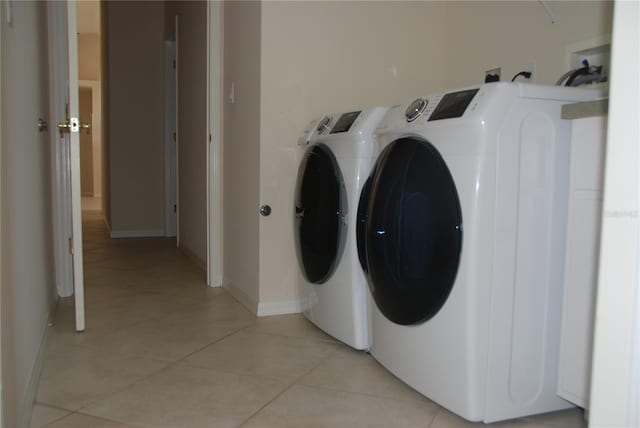 laundry room with washing machine and clothes dryer and light tile patterned flooring