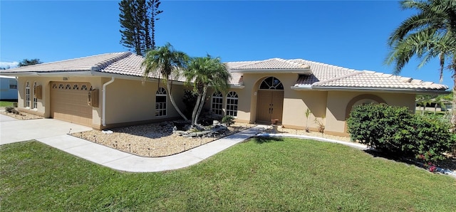 mediterranean / spanish house featuring a front lawn and a garage