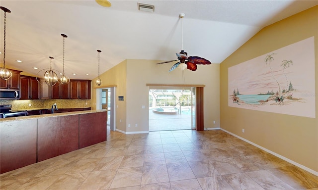 kitchen with light stone countertops, backsplash, ceiling fan with notable chandelier, stainless steel appliances, and pendant lighting