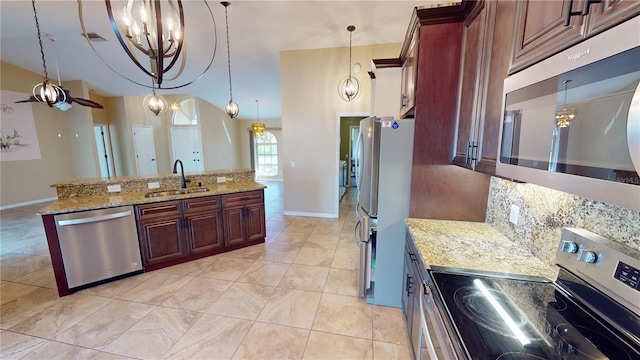 kitchen with hanging light fixtures, appliances with stainless steel finishes, sink, light tile floors, and light stone counters