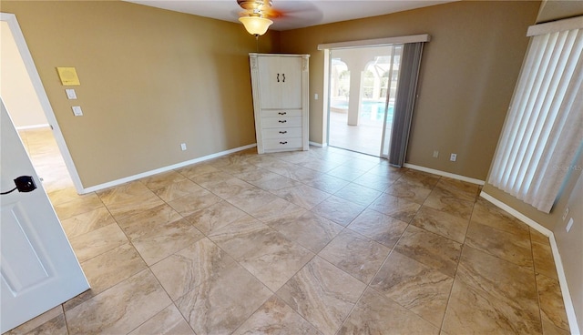 spare room featuring ceiling fan and light tile floors