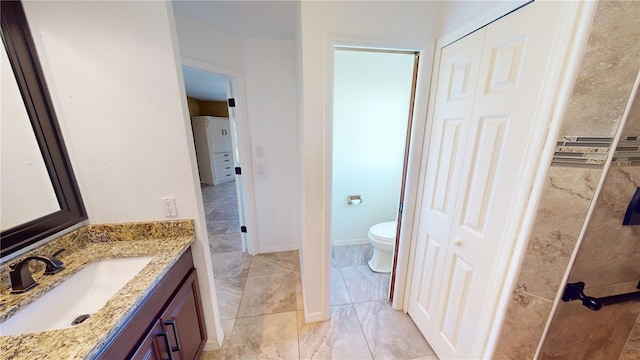 bathroom with vanity, tile floors, and toilet