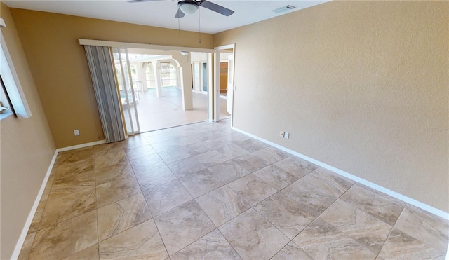 spare room featuring light tile flooring and ceiling fan